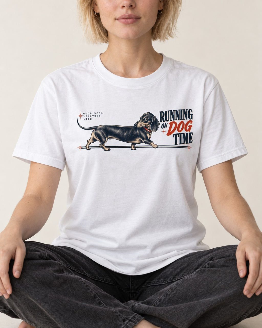 Dachshund Lengthens Life T-Shirt in White, worn by a seated model