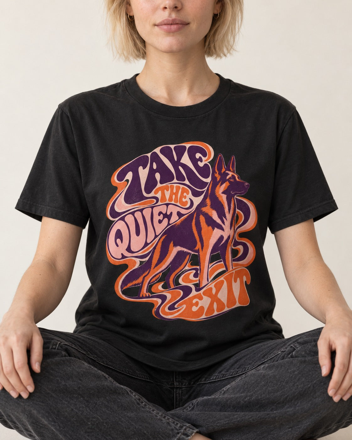 Take The Quiet Exit Psychedelic German Shepherd Dog Graphic T-Shirt in Black, worn by a seated model