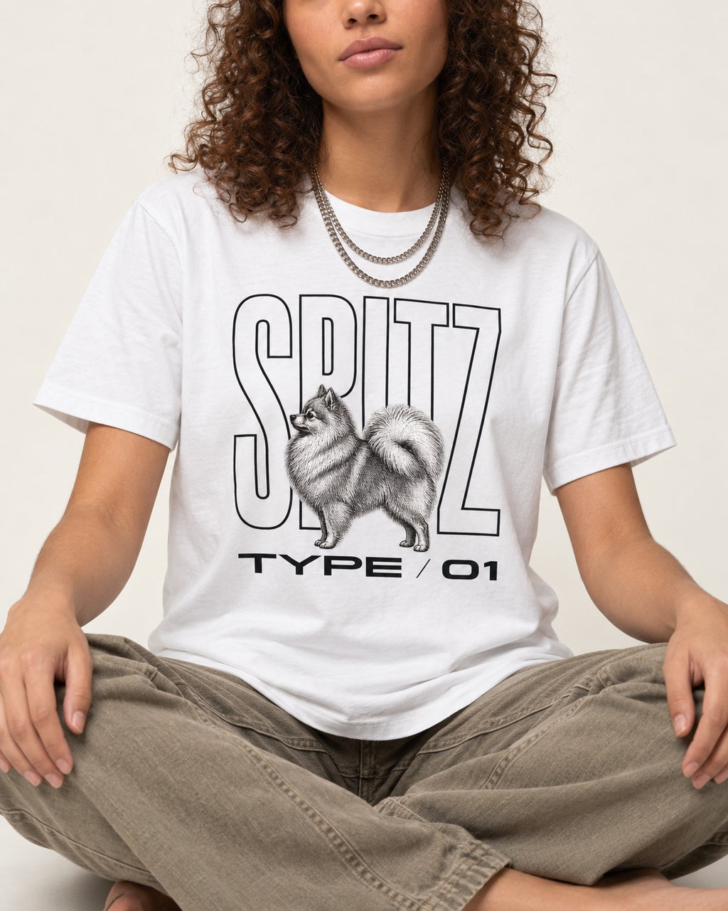 Pomeranian Spitz T-Shirt in White, worn by a seated model