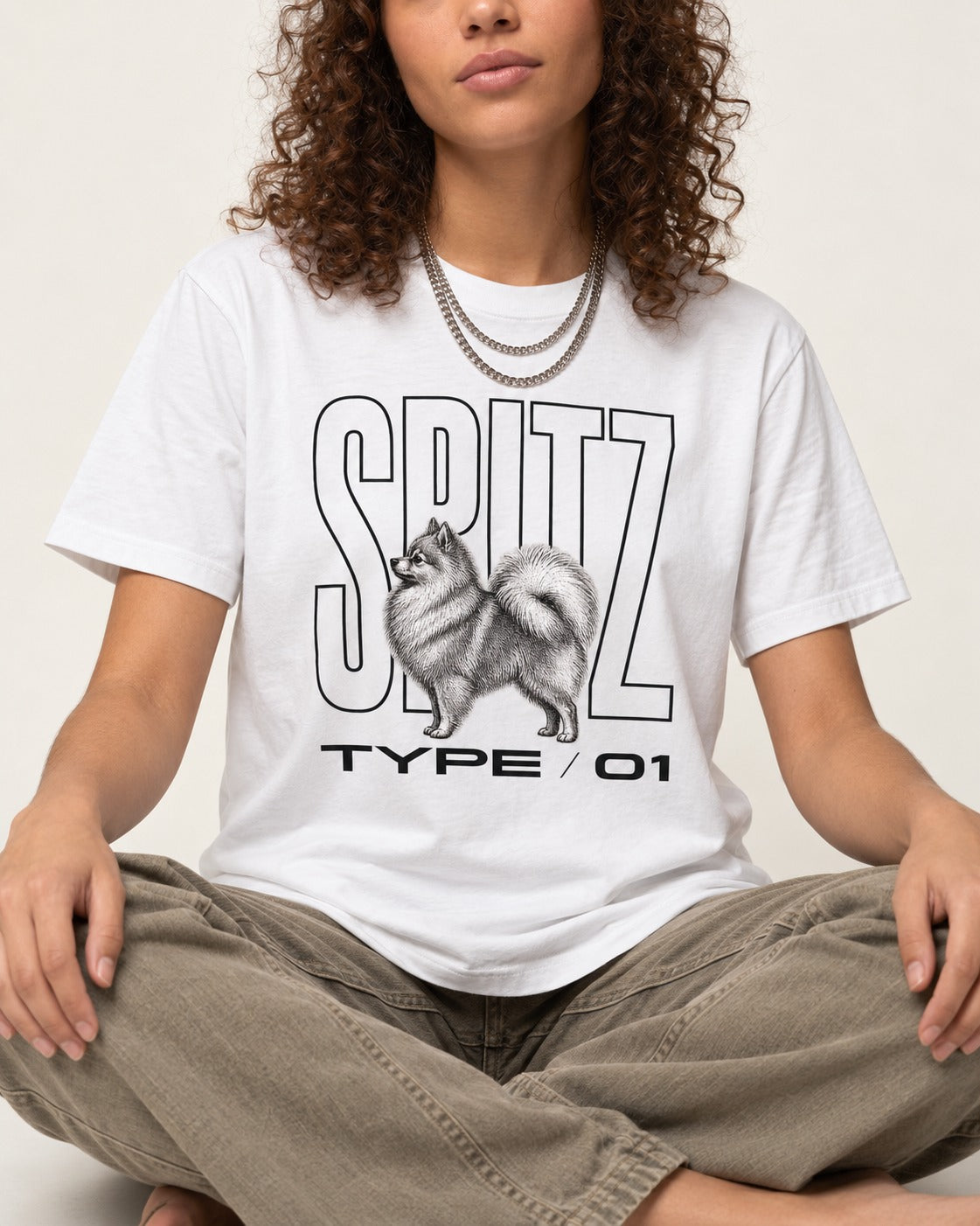 Pomeranian Spitz T-Shirt in White, worn by a seated model