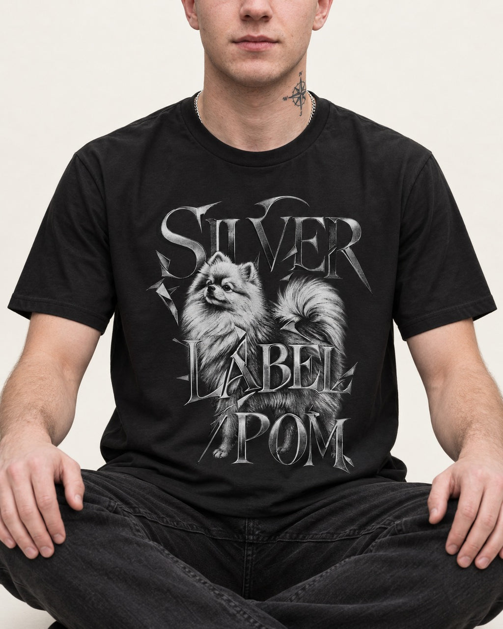 Pomeranian Silver Label Metallic Typography Graphic T-Shirt in Black, worn by a seated model