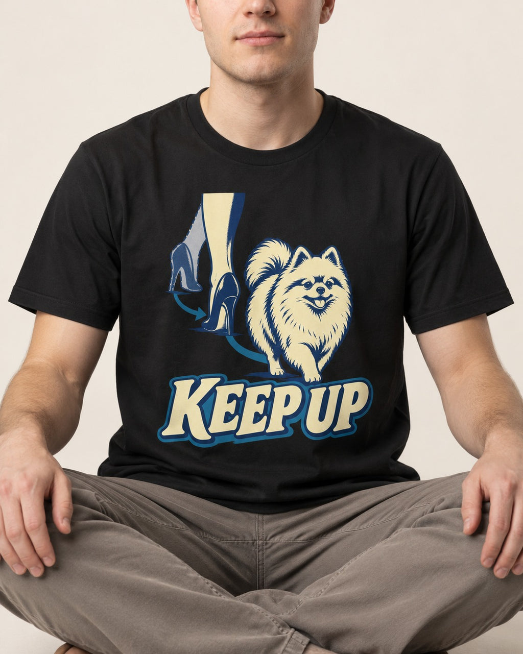Pomeranian Keep Up High Heel Chase Graphic T-Shirt in Black, worn by a seated model