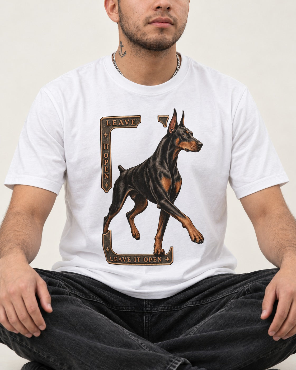 Leave It Open Doberman T-Shirt in White, worn by a seated model