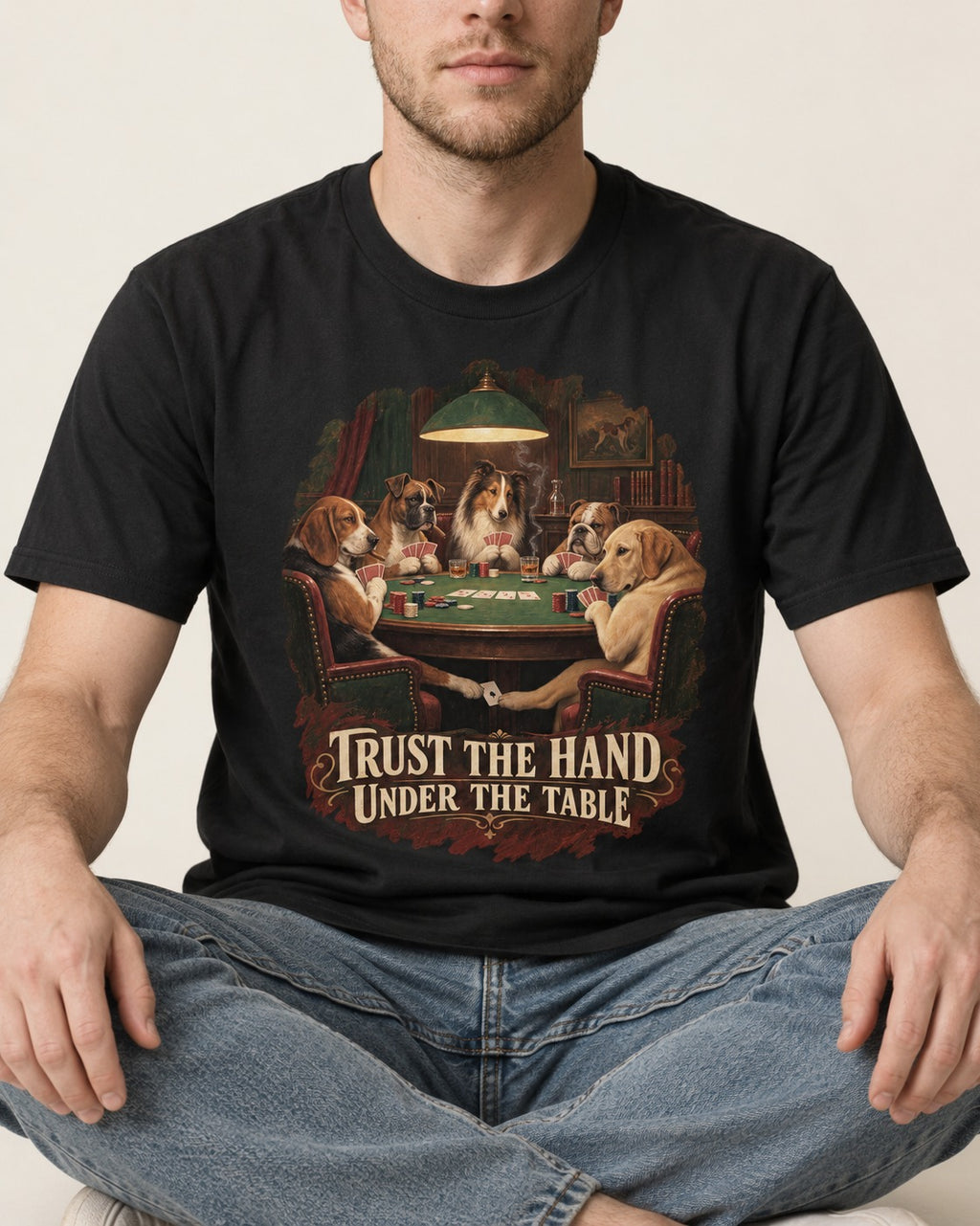 Labrador Retriever Trust the Hand Under the Table Poker Dogs Graphic T-Shirt in Black, worn by a seated model
