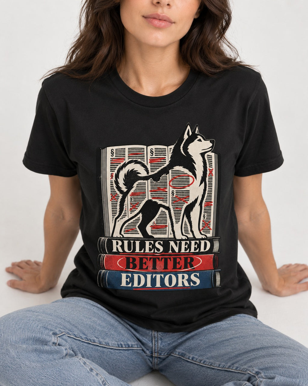 Husky Rules Need Better Editors Book Stack Graphic T-Shirt in Black, worn by a seated model