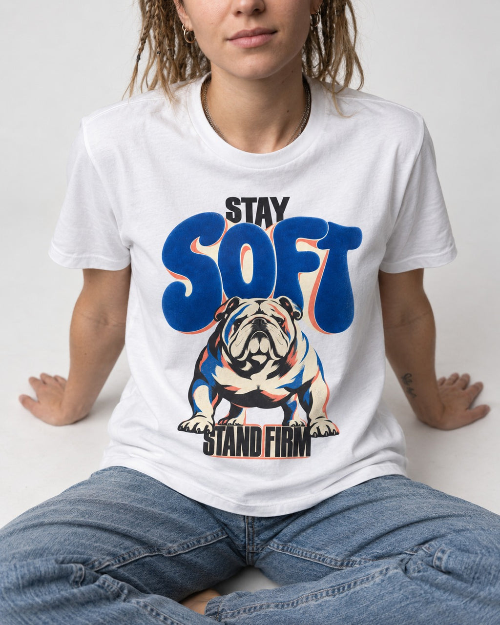 Stay Soft Stand Firm English Bulldog T-Shirt in White, worn by a seated model
