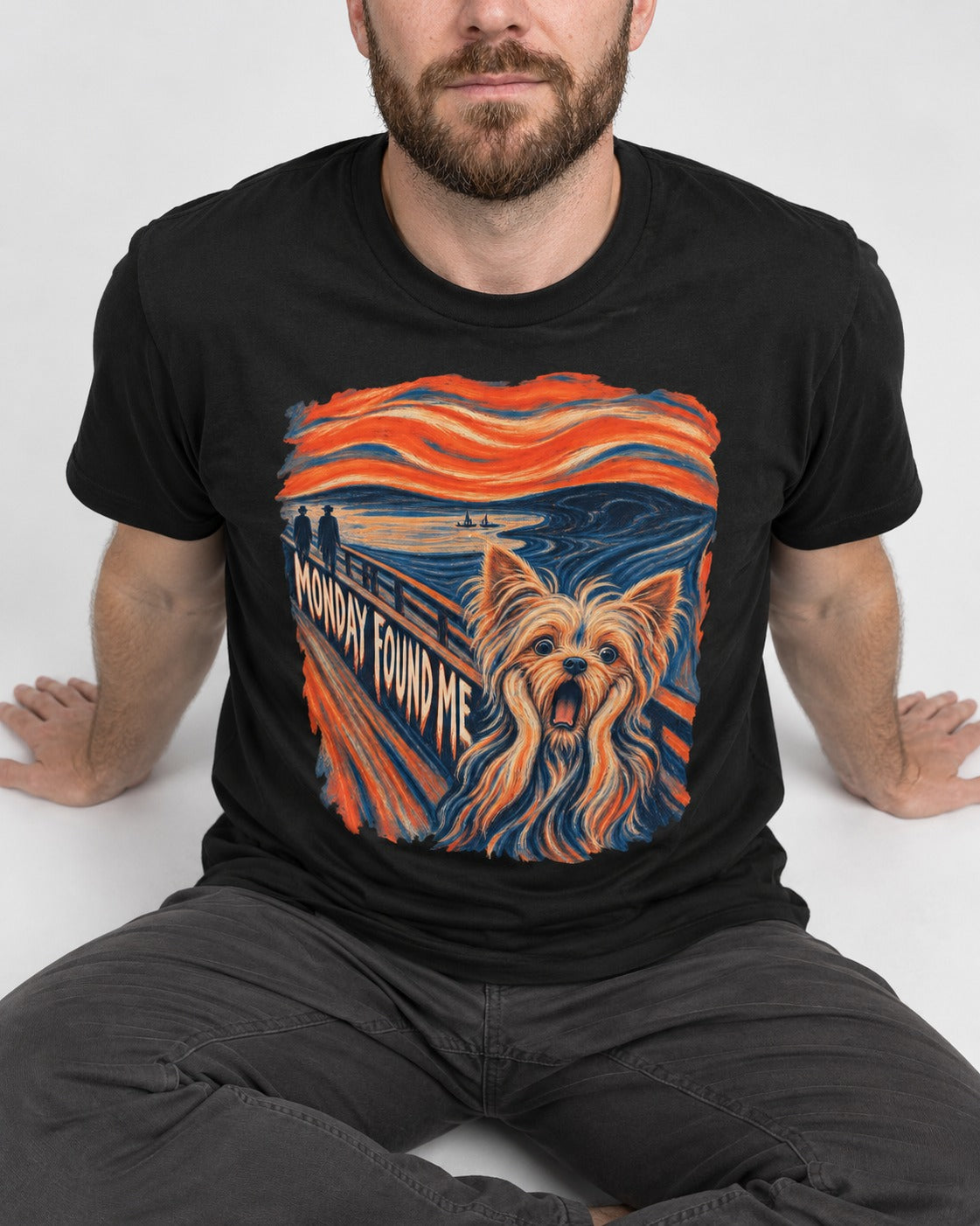 Yorkshire Terrier Monday Found Me Scream Parody Graphic T-Shirt in Black, worn by a seated model