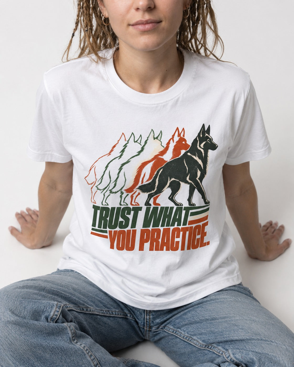 Trust What You Practice German Shepherd Dog T-Shirt in White, worn by a seated model