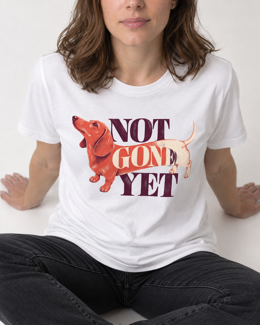 Dachshund Not Gone Yet T-Shirt in White, worn by a seated model
