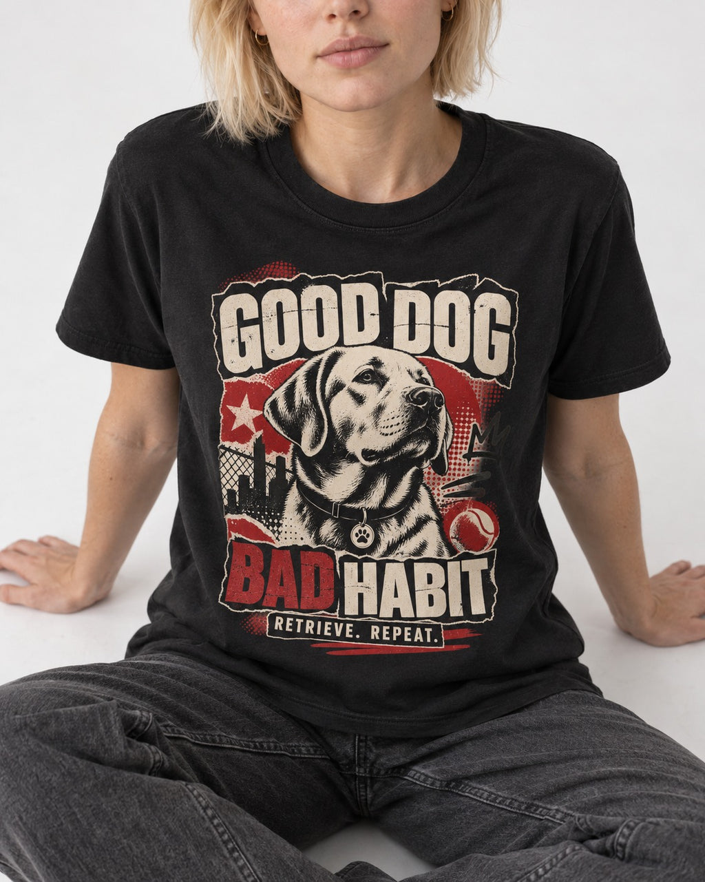 Labrador Retriever Good Dog Bad Habit Poster Graphic T-Shirt in Black, worn by a seated model