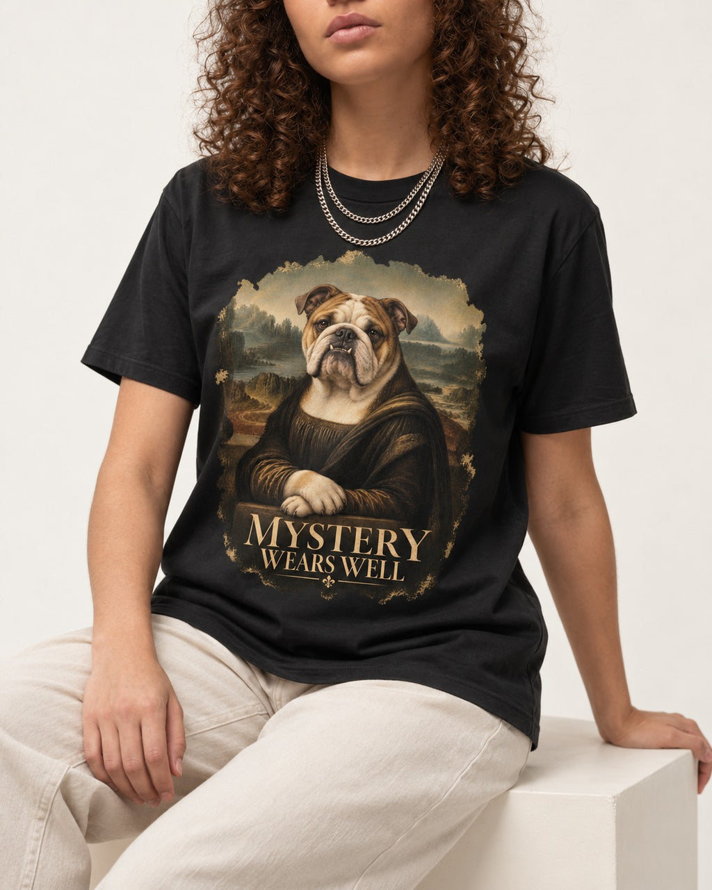 English Bulldog Mystery Wears Well Mona Lisa Portrait T-Shirt in Black, worn by a seated model