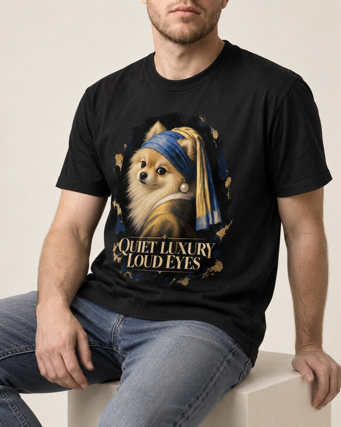 Pomeranian Quiet Luxury Loud Eyes Pearl Portrait Graphic T-Shirt in Black, worn by a seated model