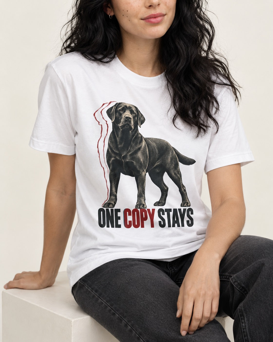 One Copy Stays Labrador Retriever T-Shirt in White, worn by a seated model