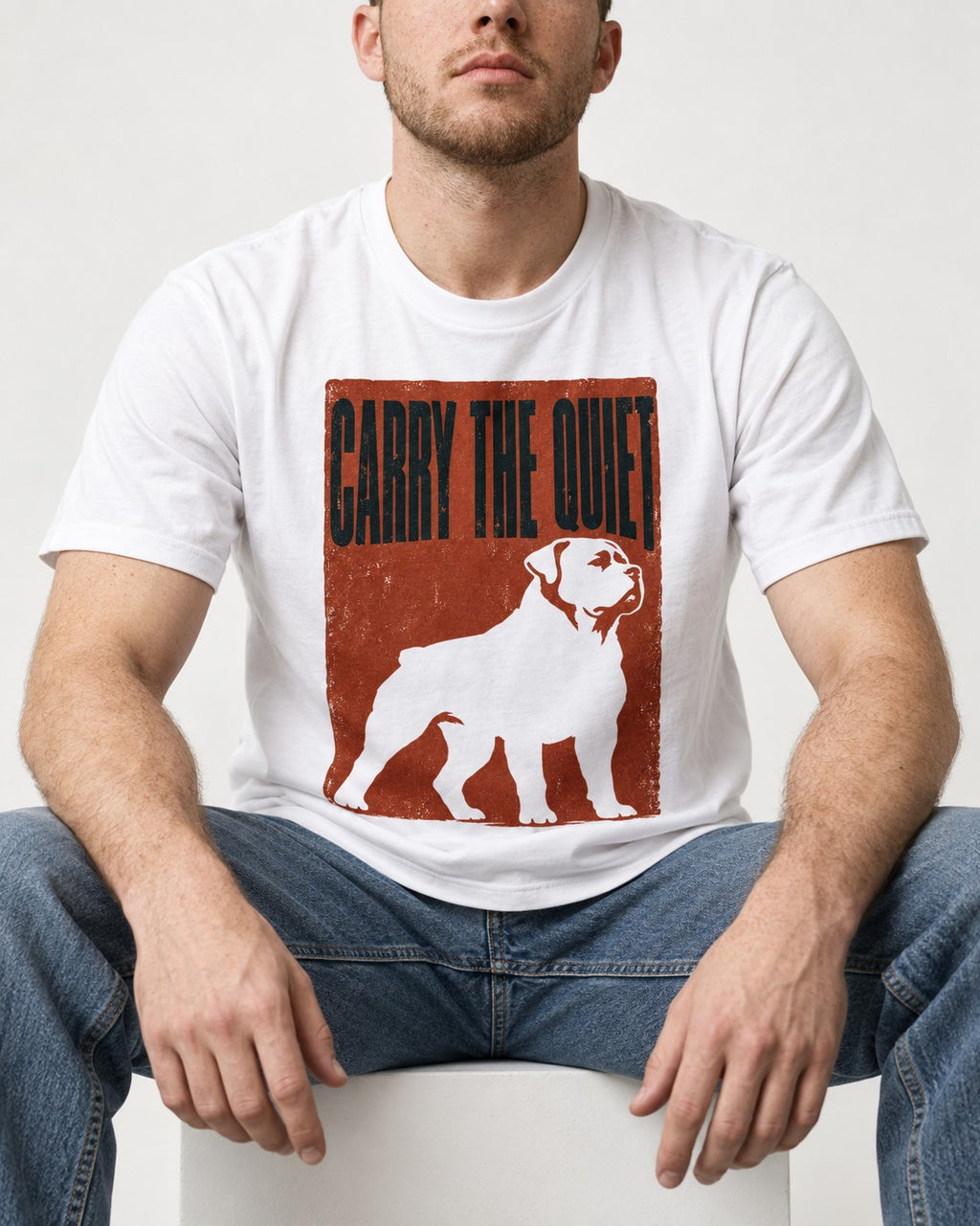 Rottweiler Carry the Quiet T-Shirt in White, worn by a seated model