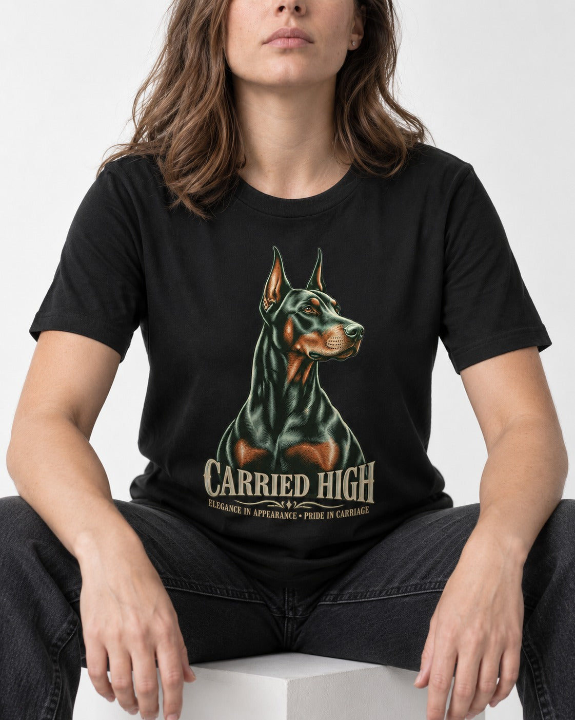 Doberman Carried High Portrait Graphic T-Shirt in Black, worn by a seated model