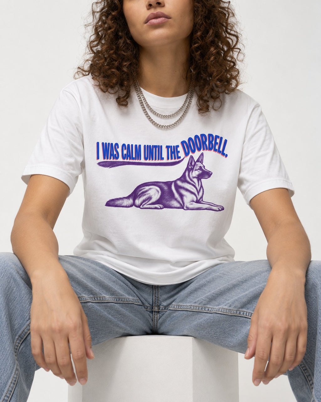 German Shepherd Dog Calm Until the Doorbell T-Shirt in White, worn by a seated model
