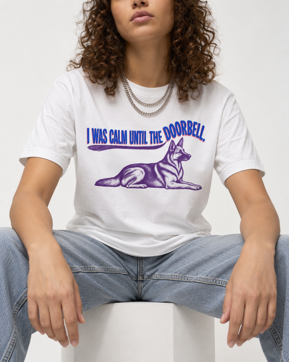 German Shepherd Dog Calm Until the Doorbell T-Shirt in White, worn by a seated model