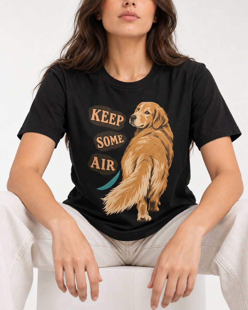 Golden Retriever Keep Some Air Looking Back Graphic T-Shirt in Black, worn by a seated model