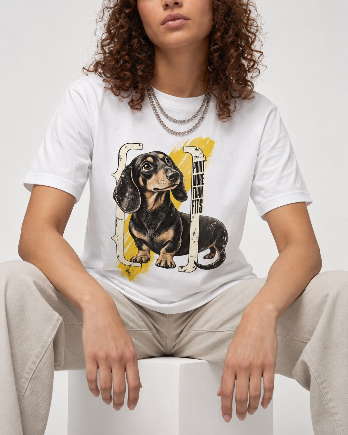 Dachshund More Than Fits T-Shirt in White, worn by a seated model