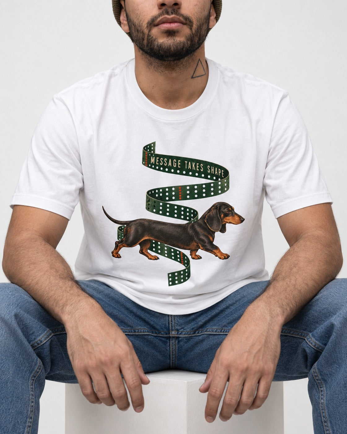 Dachshund Message Takes Shape T-Shirt in White, worn by a seated model