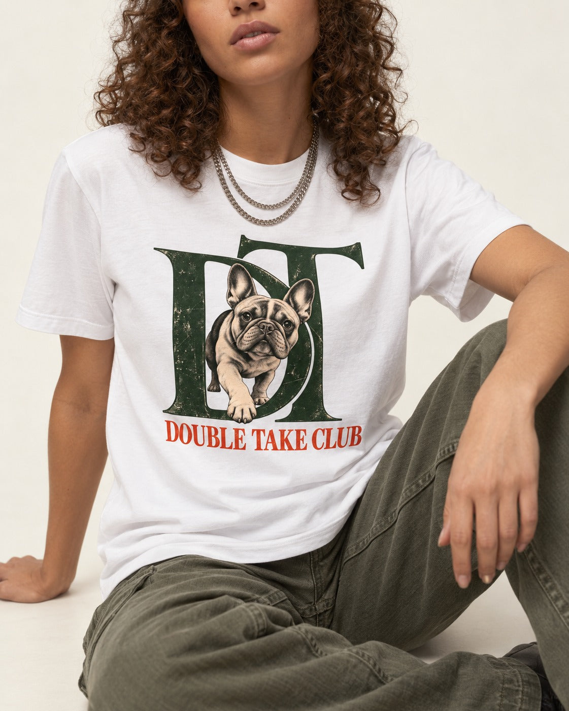 Frenchie Double Take Club T-Shirt in White, worn by a seated model