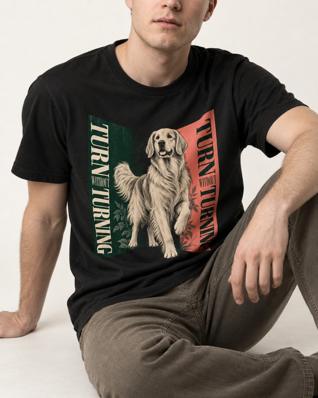 Golden Retriever Turn Without Turning Gateway Graphic T-Shirt in Black, worn by a seated model