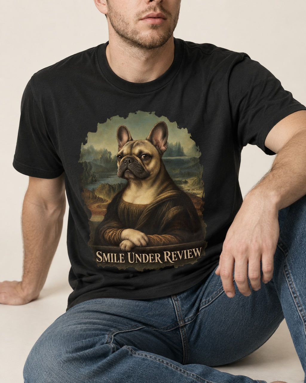 Frenchie Smile Under Review Renaissance Portrait T-Shirt in Black, worn by a seated model