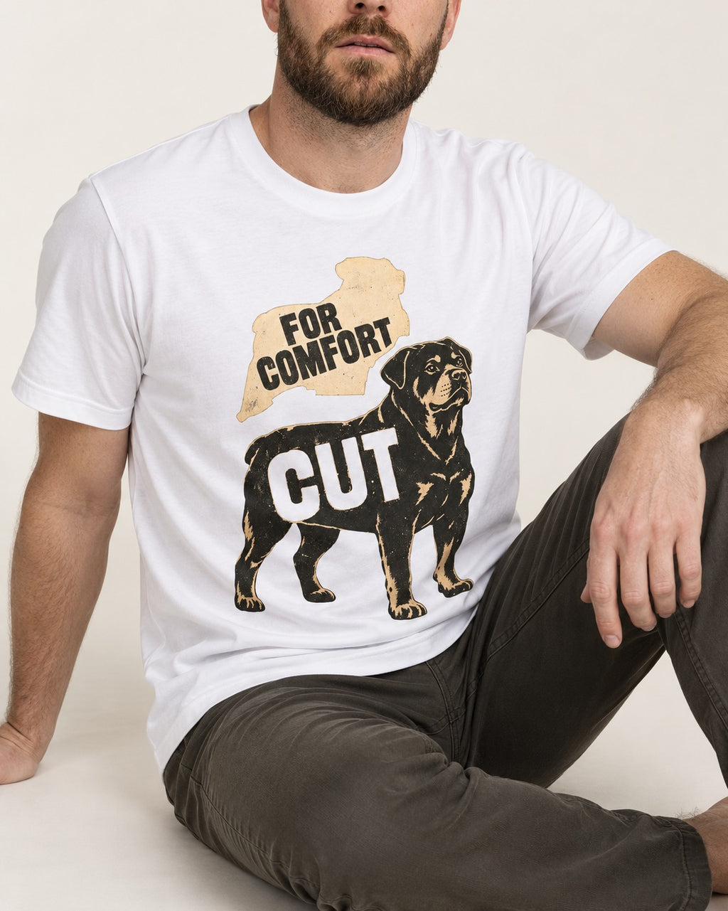Rottweiler Cut for Comfort T-Shirt in White, worn by a seated model