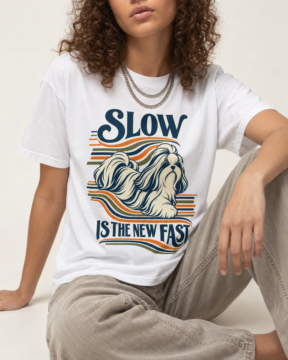 Slow Is Fast Shih Tzu T-Shirt in White, worn by a seated model