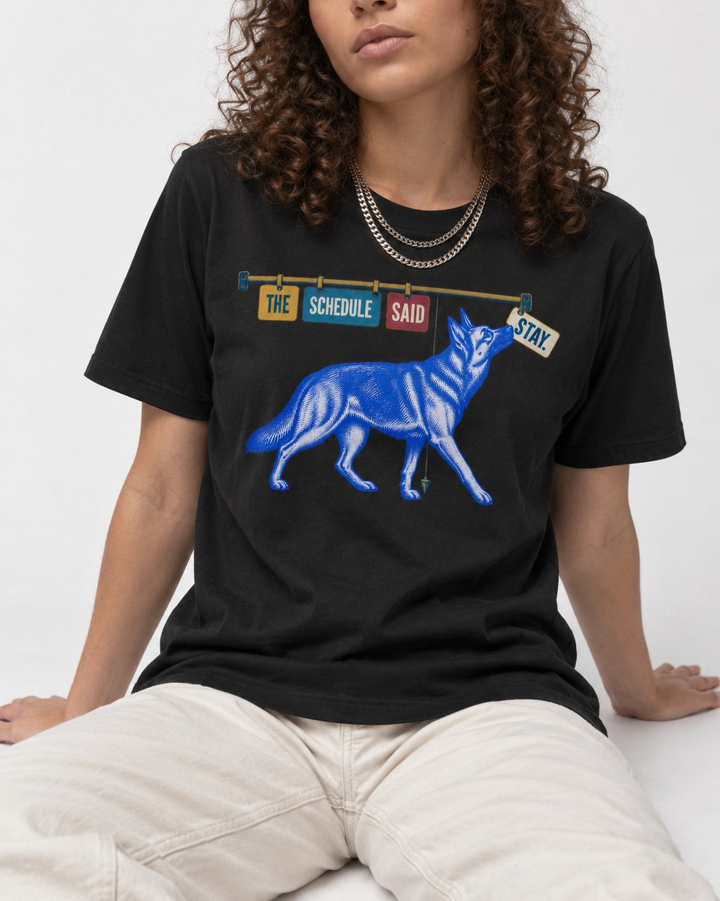 German Shepherd Dog The Schedule Said Stay Graphic T-Shirt in Black, worn by a seated model
