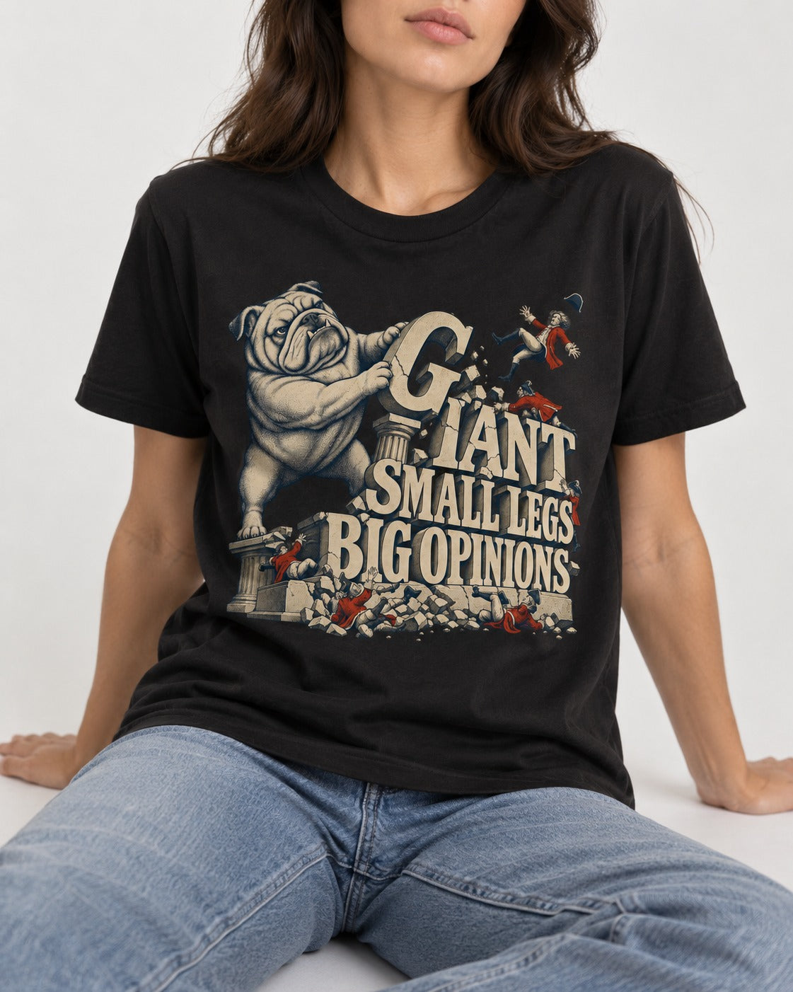 English Bulldog Giant Small Legs Big Opinions Monument Graphic T-Shirt in Black, worn by a seated model