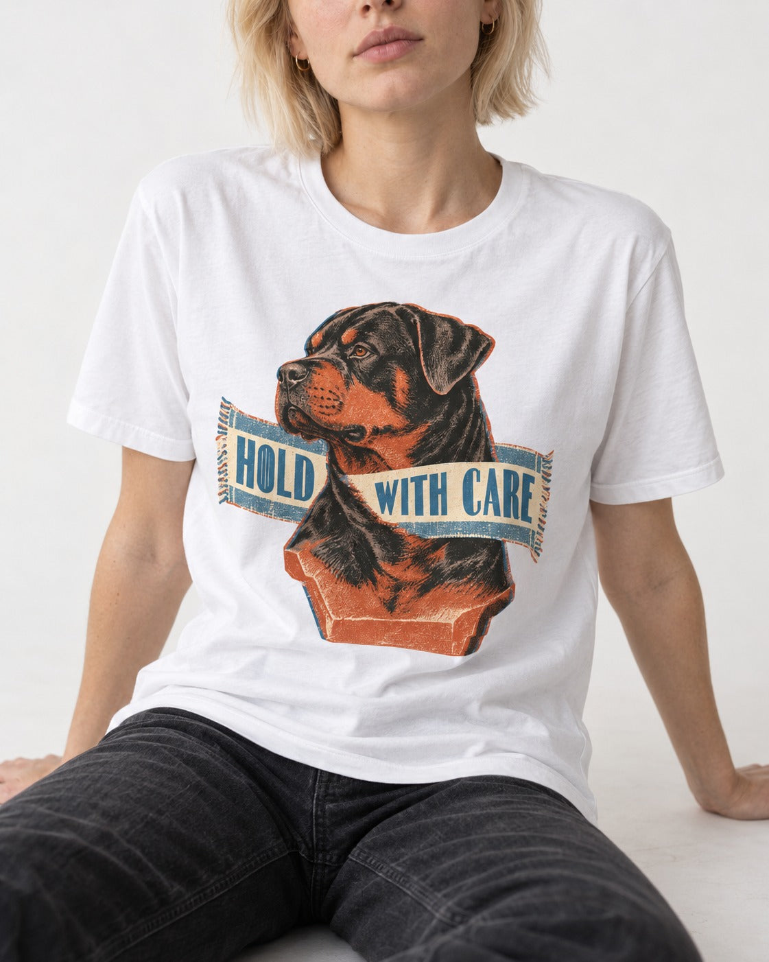 Rottweiler Hold with Care T-Shirt in White, worn by a seated model