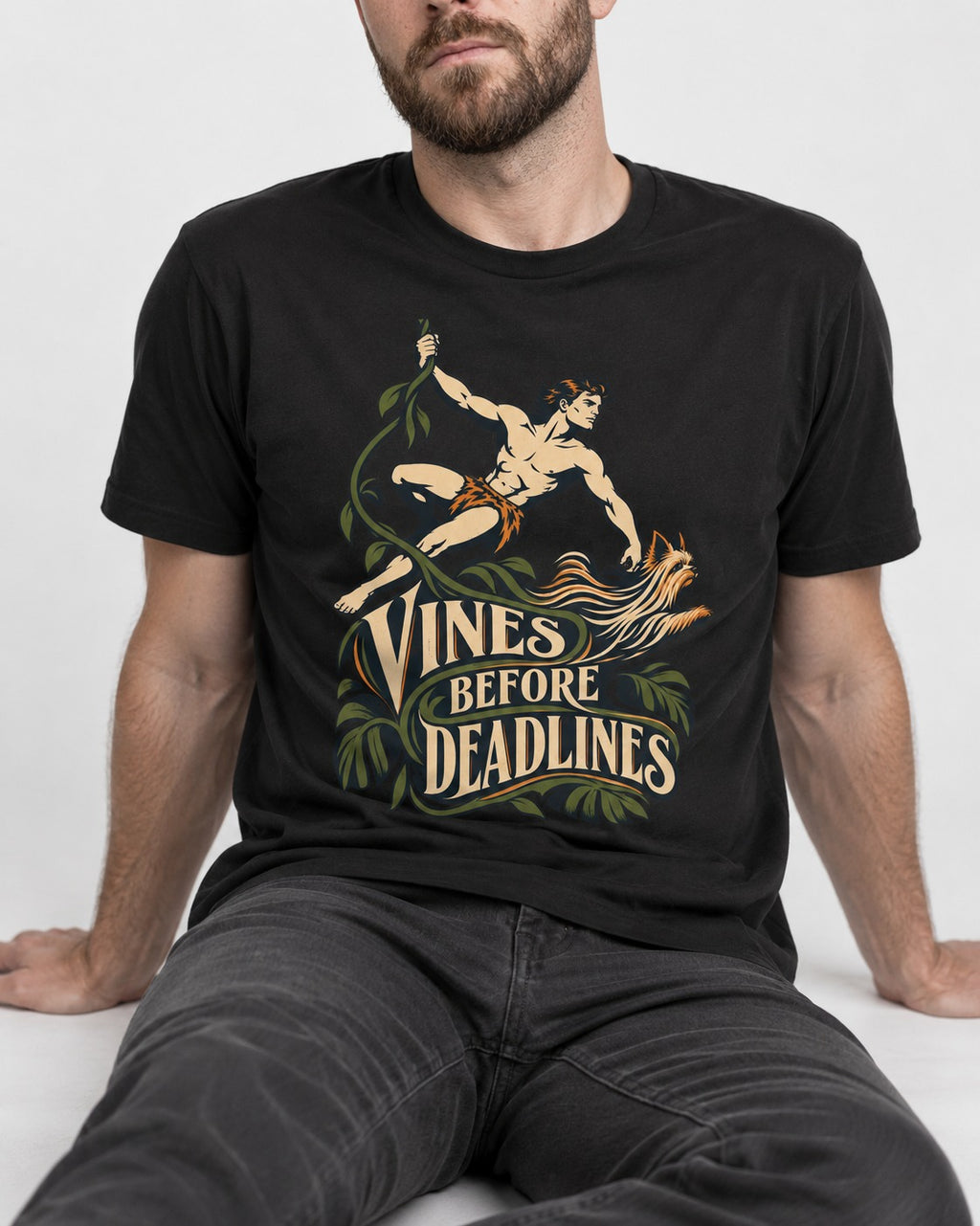 Yorkshire Terrier Vines Before Deadlines Jungle Hero Graphic T-Shirt in Black, worn by a seated model