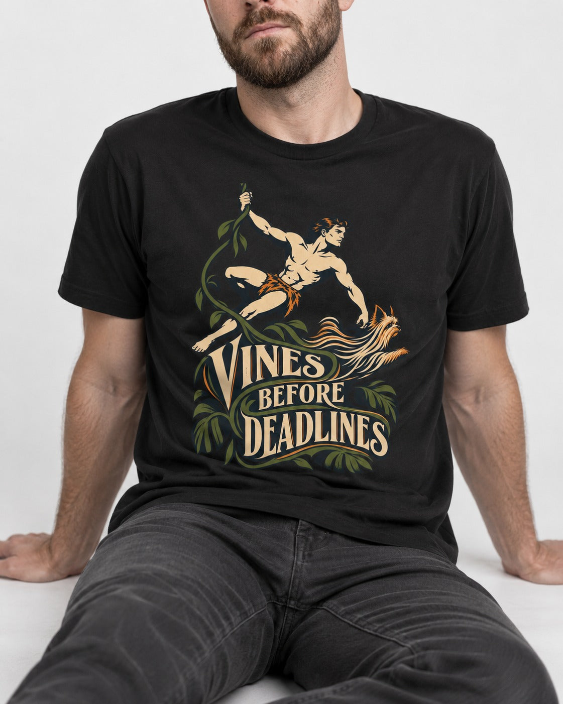 Yorkshire Terrier Vines Before Deadlines Jungle Hero Graphic T-Shirt in Black, worn by a seated model