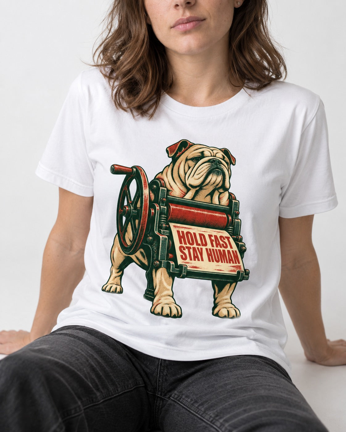 Hold Fast Stay Human English Bulldog T-Shirt in White, worn by a seated model