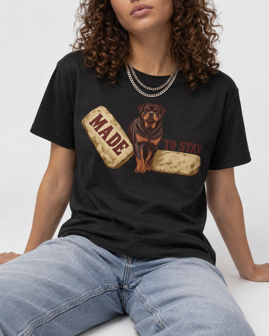Rottweiler Made to Stay Stepping Stone Graphic T-Shirt in Black, worn by a seated model