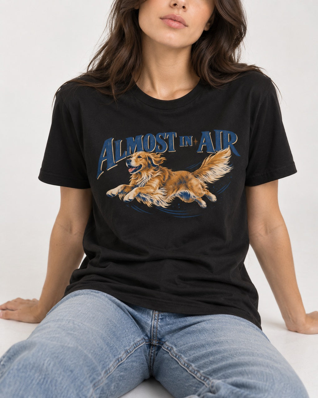 Golden Retriever Almost in Air Flying Graphic T-Shirt in Black, worn by a seated model