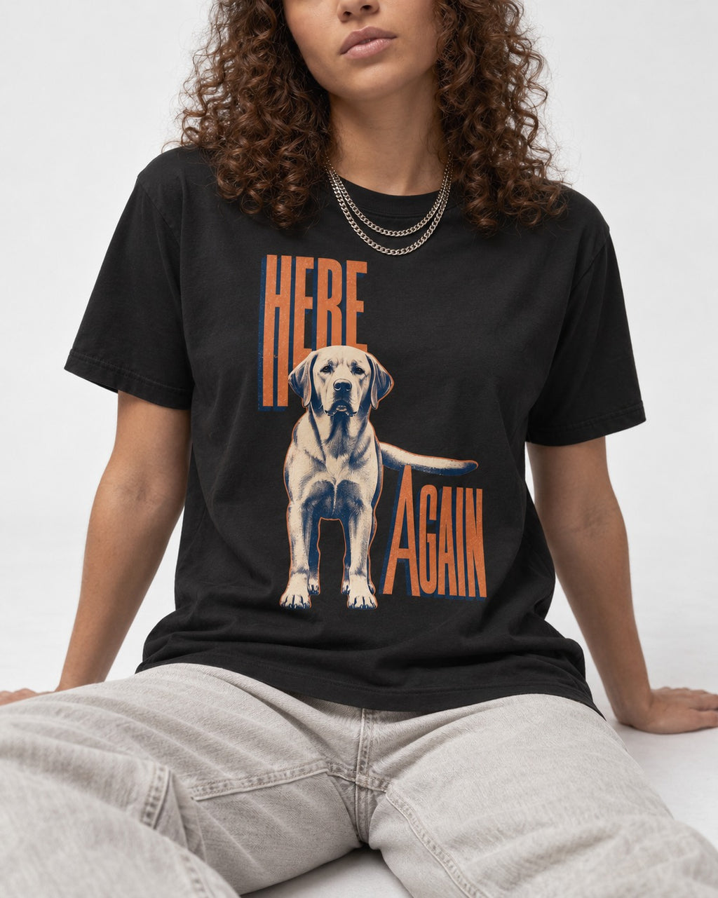 Labrador Retriever Here Again Standing Typography Graphic T-Shirt in Black, worn by a seated model