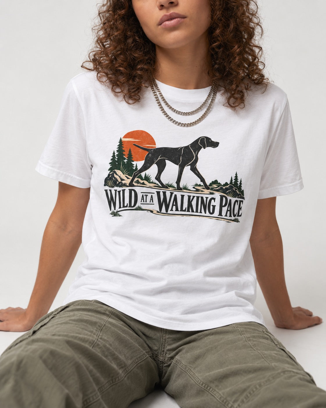 Wild at a Walk German Shorthaired Pointer T-Shirt in White, worn by a seated model