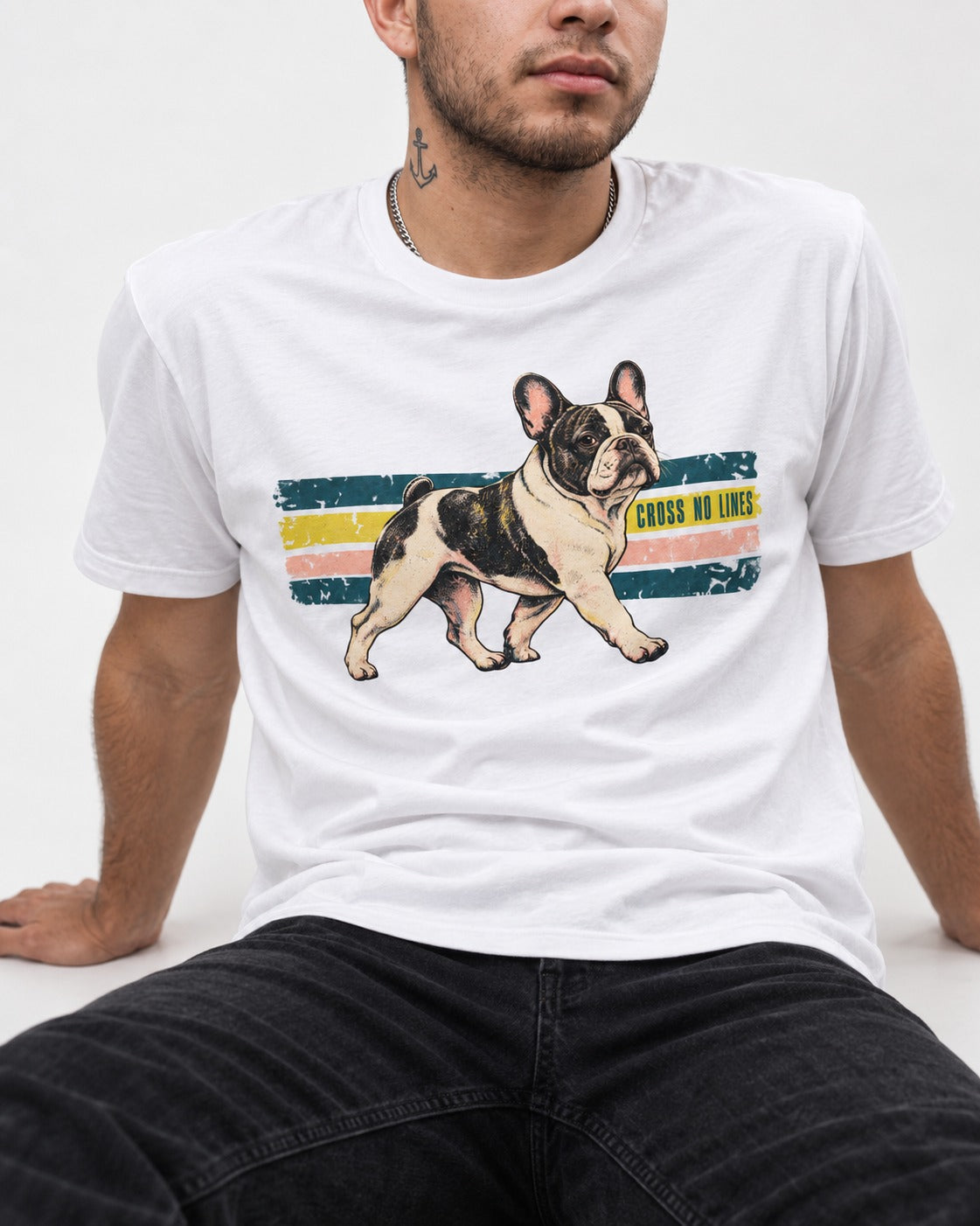 Frenchie Cross No Lines T-Shirt in White, worn by a seated model