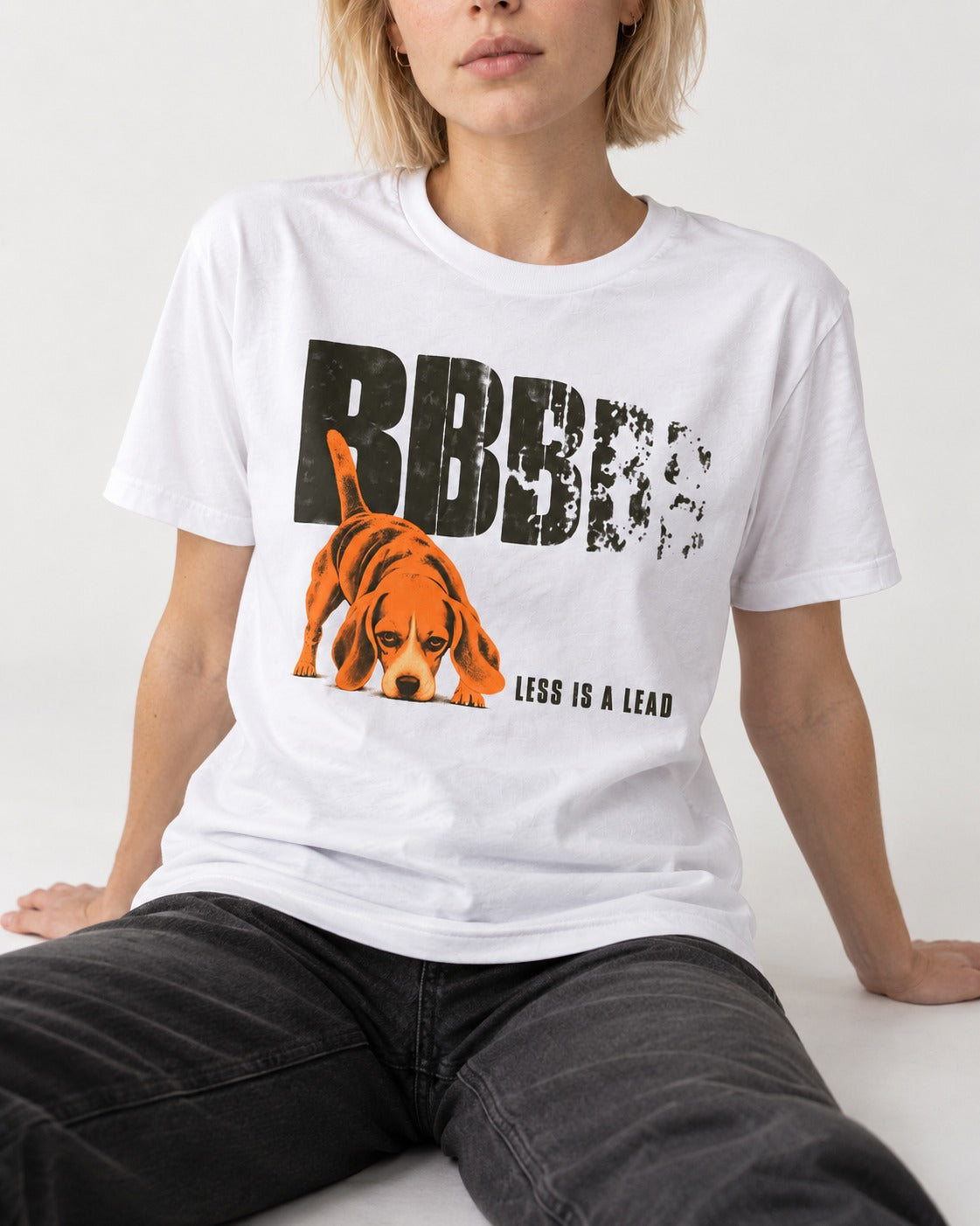 Less Is a Lead Beagle T-Shirt in White, worn by a seated model