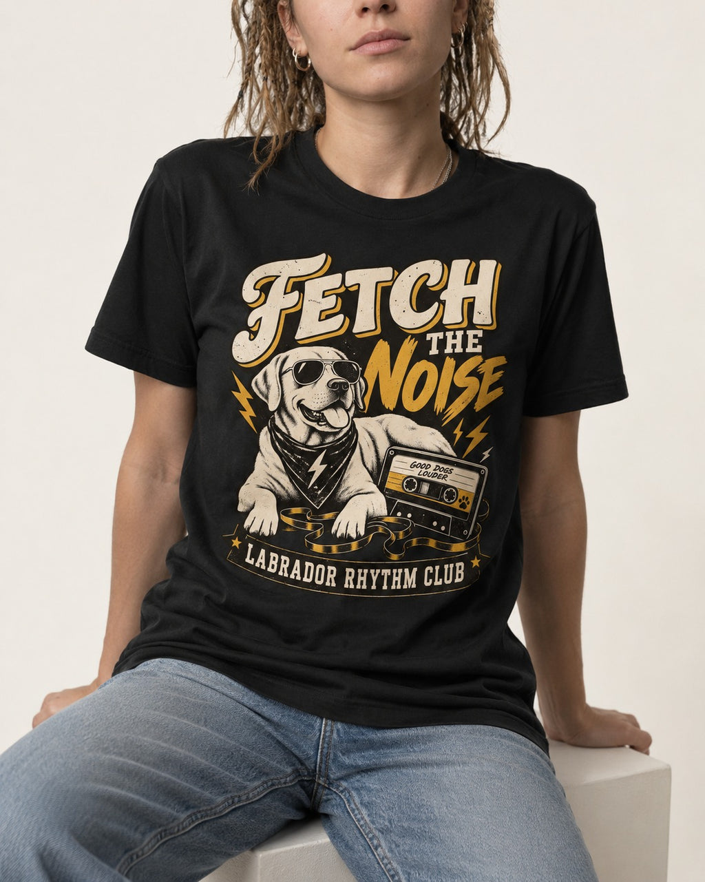 Labrador Retriever Fetch the Noise Rhythm Club DJ Graphic T-Shirt in Black, worn by a seated model
