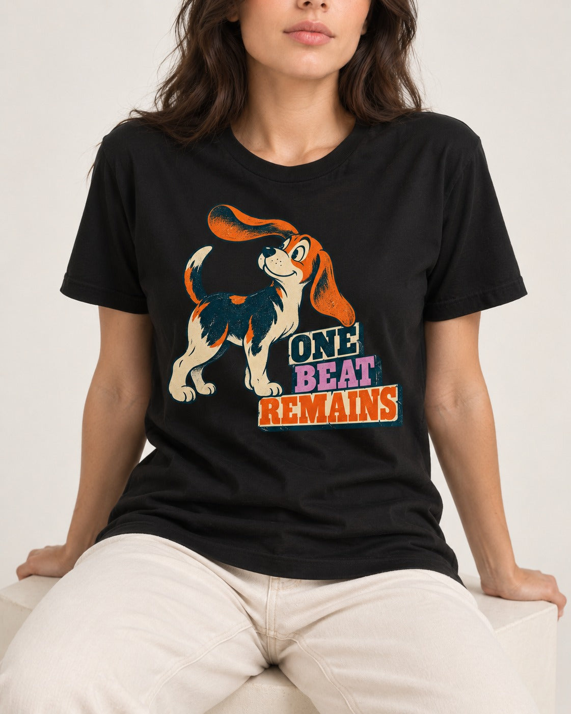 Retro Beagle One Beat Remains T-Shirt in Black, worn by a seated model