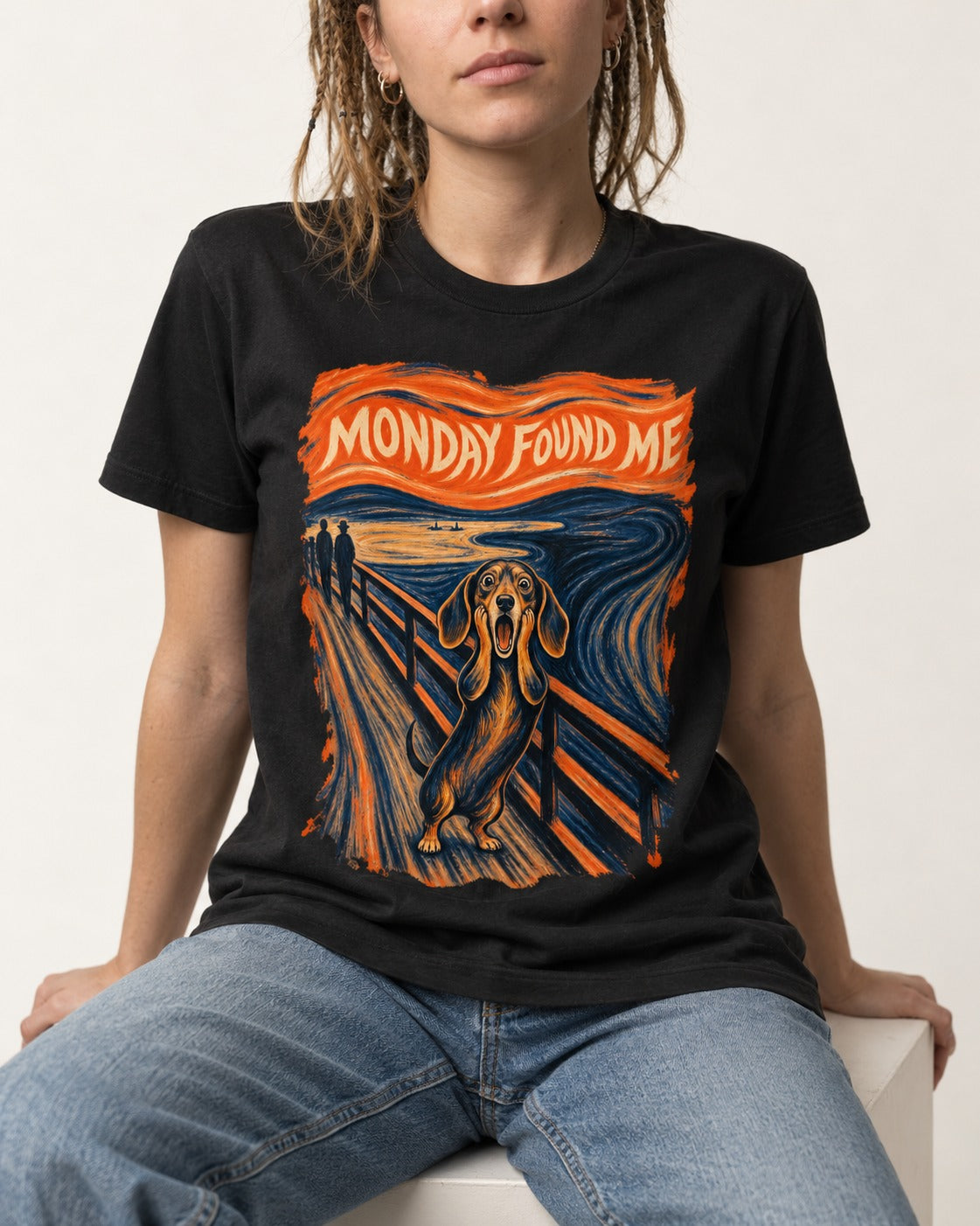 Dachshund Monday Found Me Scream Poster T-Shirt in Black, worn by a seated model