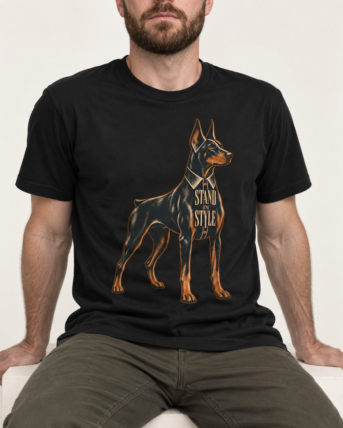 Doberman Stand in Style Suit Graphic T-Shirt in Black, worn by a seated model