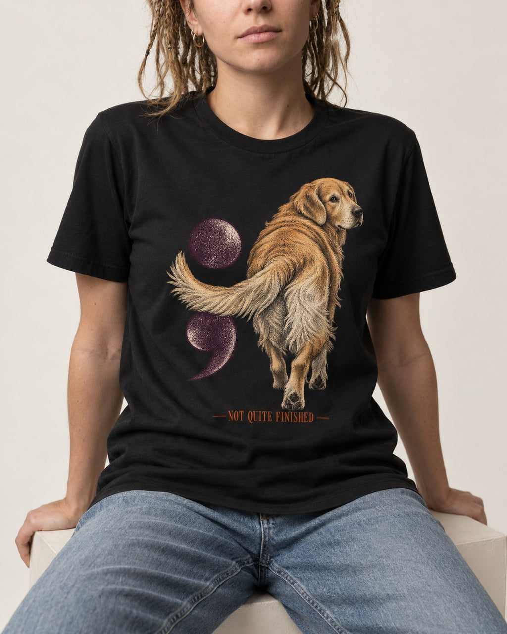 Golden Retriever Not Quite Finished Semicolon Graphic T-Shirt in Black, worn by a seated model