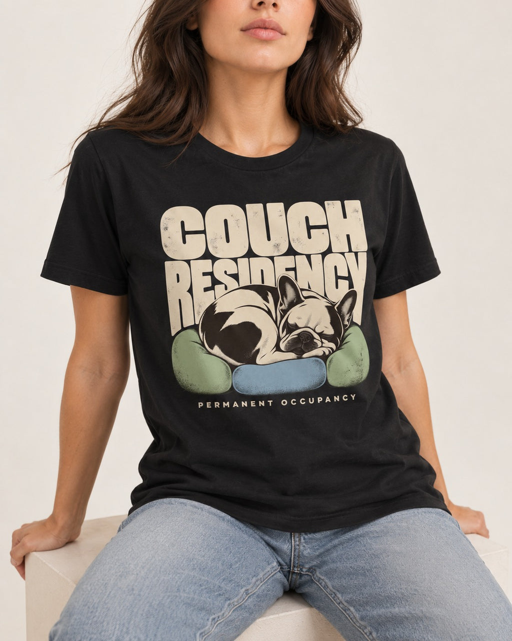 Frenchie Couch Residency Permanent Occupancy Cushion Graphic T-Shirt in Black, worn by a seated model