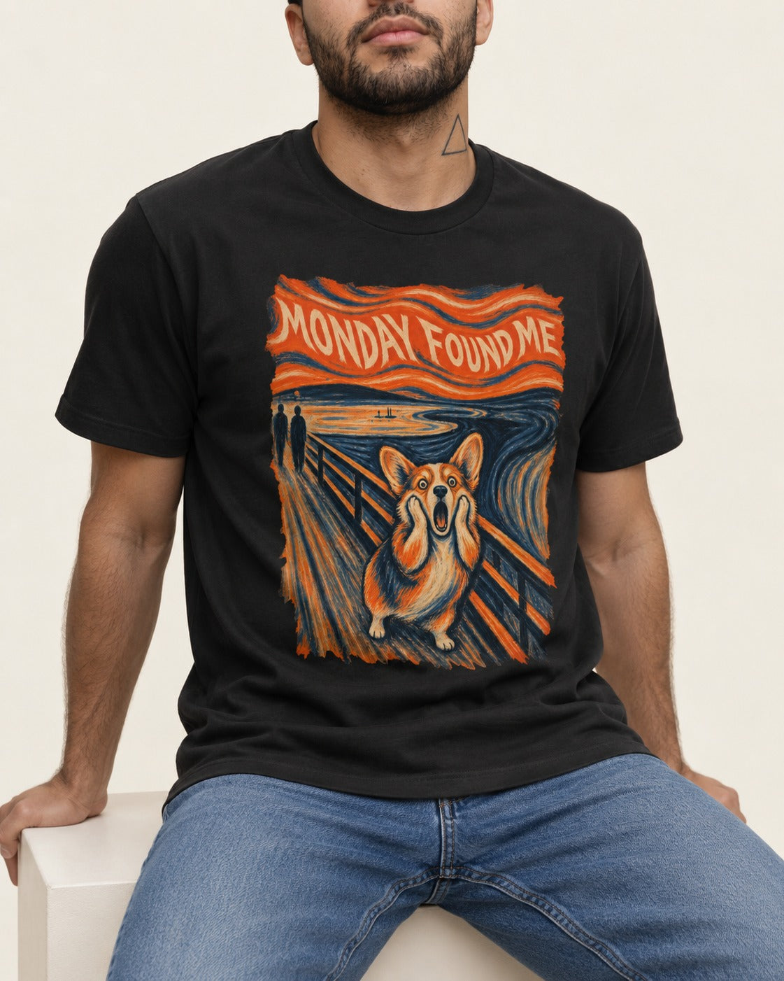 Corgi Monday Found Me Scream Banner T-Shirt in Black, worn by a seated model
