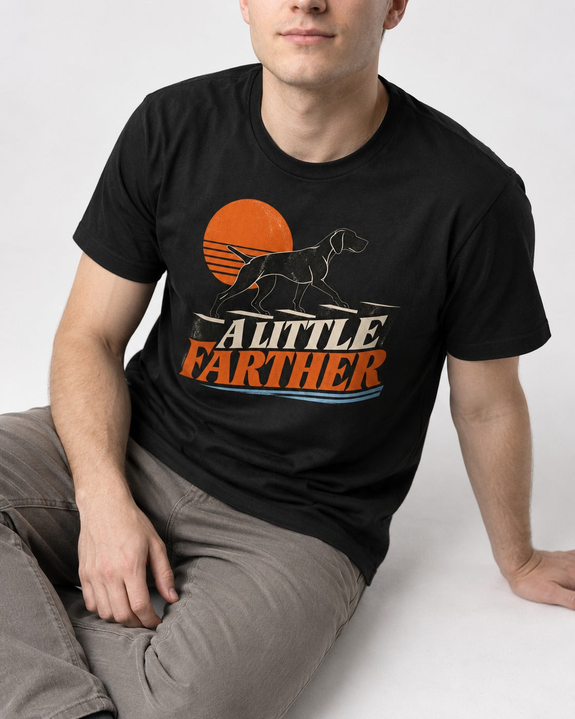 German Shorthaired Pointer A Little Farther Sunset Steps Graphic T-Shirt in Black, worn by a seated model