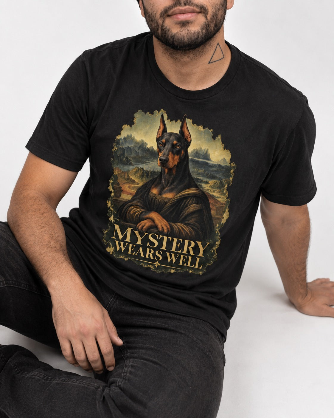 Doberman Mystery Wears Well Renaissance Portrait Graphic T-Shirt in Black, worn by a seated model